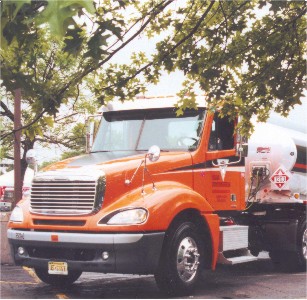 Cover Photo: Tanker truck with red cab and hazardous materials placard.